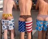 Three friends at a beach bar wearing Cheeky Swim Trunks in Surf Van, USA Leopard and Tropical prints